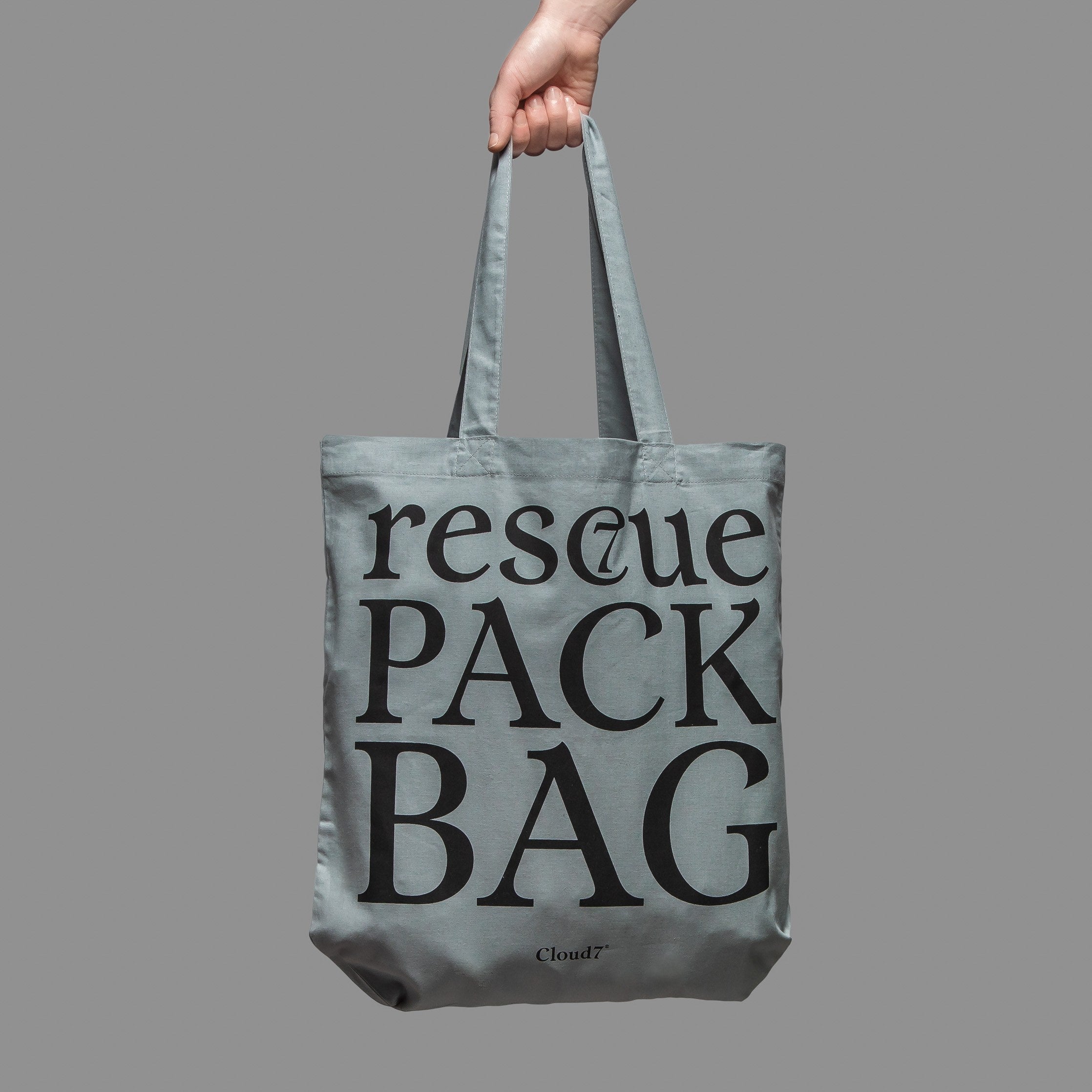 Hand hält graue Statement Stofftasche für Charity-Zwecke